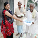 Mrs. Seema Singh distributing clothes to pooress